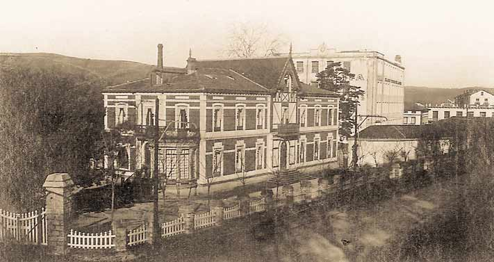 El palacete Brunet con su fachada, galería acristalada y el edificio fabril detrás